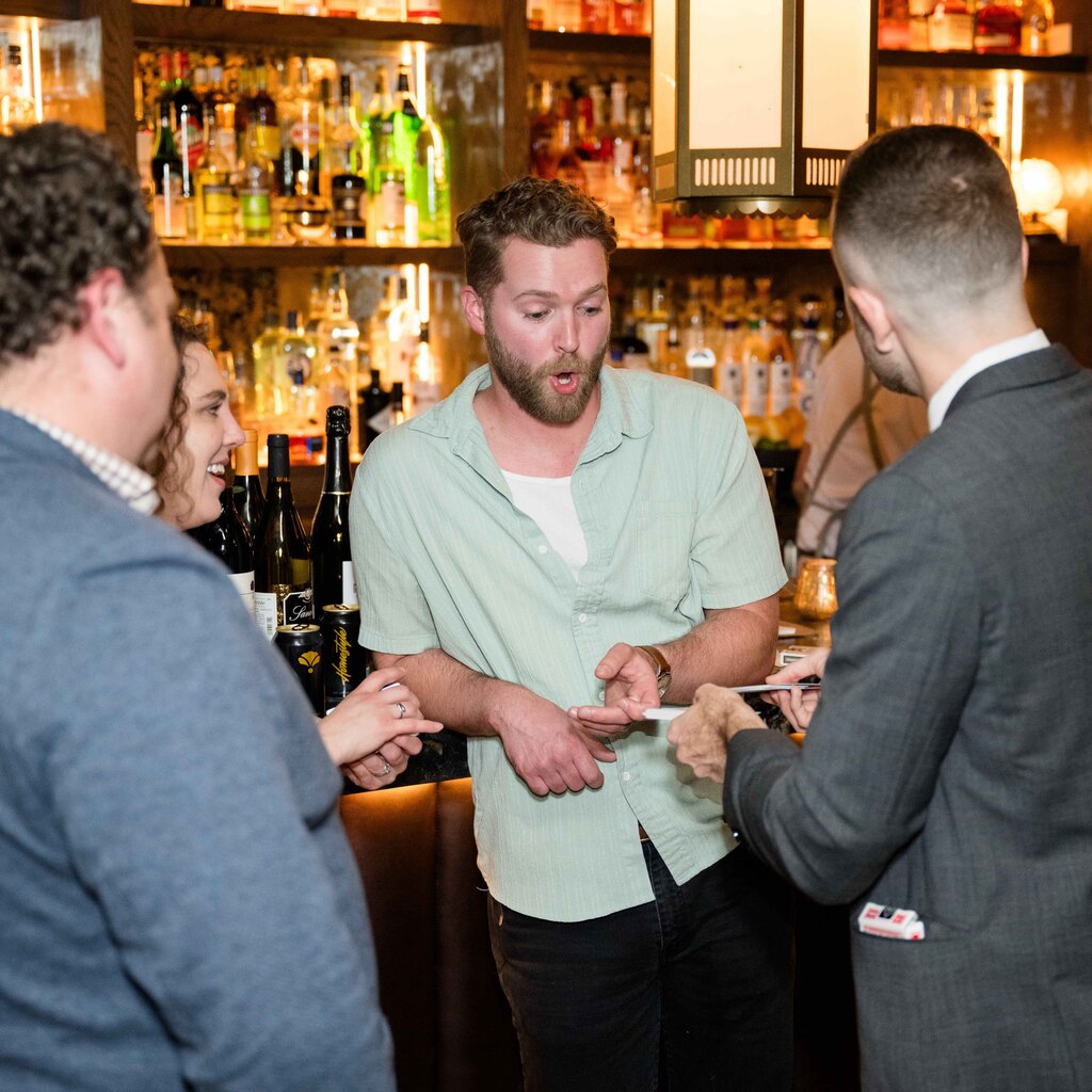 Frankie Foti performing close-up magic for guests at a bar in Nashville