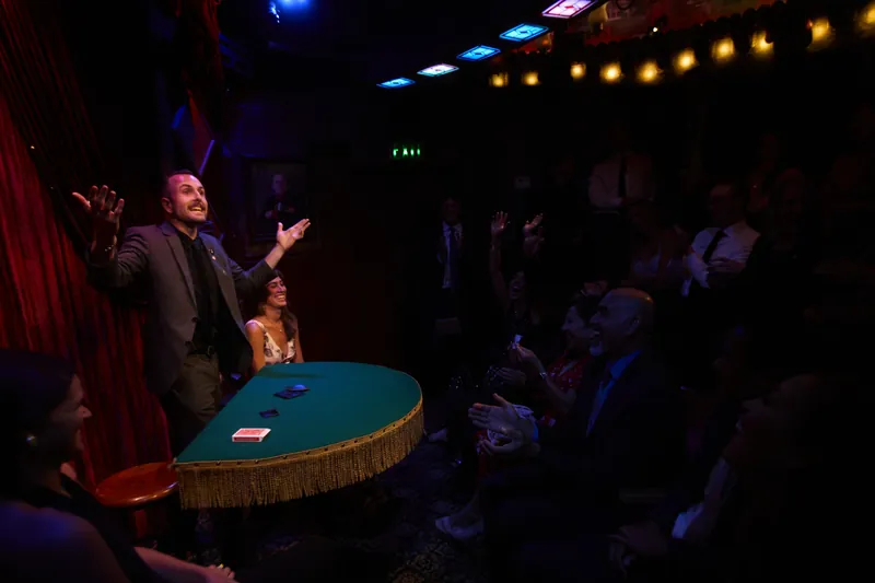 A seated audience watching a close-up show performed at a small table