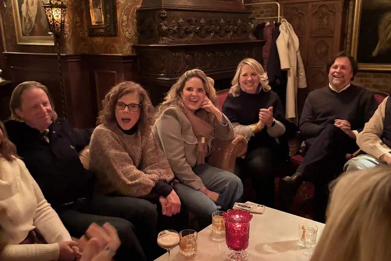 Seated guests laughing during a close-up performance at their table